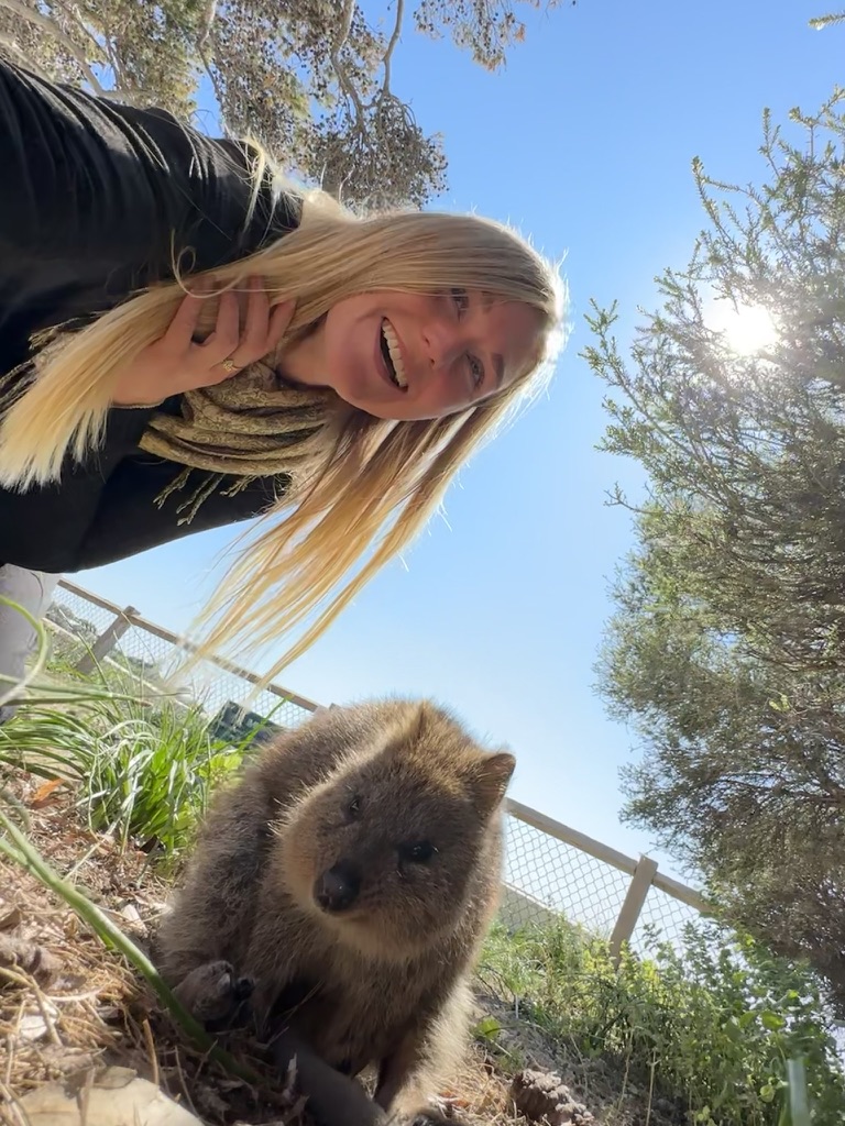 Alleinreisende Frau In Australien mit Quokka. Sichere Reiseziele für Alleinreisende Frauen.