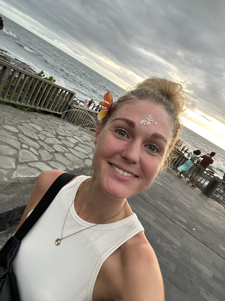 Alleinreisende Frau mit Blume im Haar auf Bali.