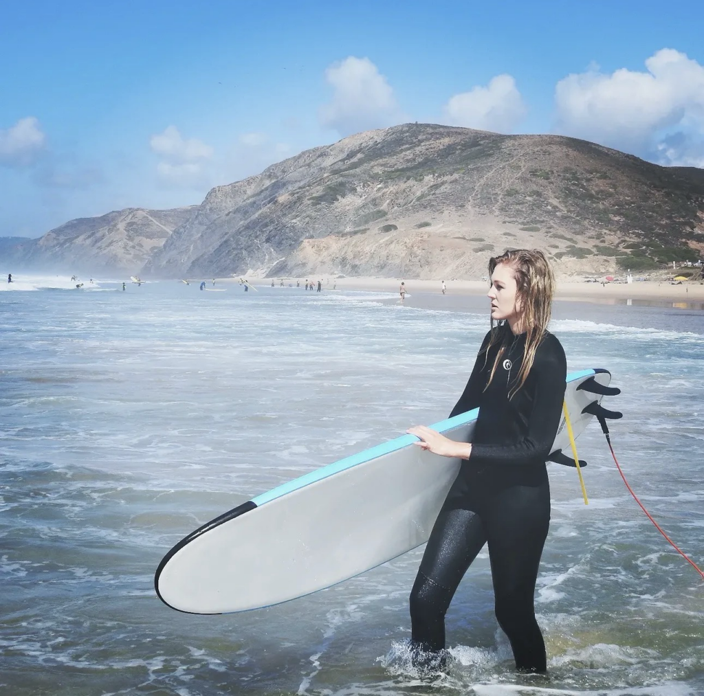 Frau mit Surfbrett in Portugal