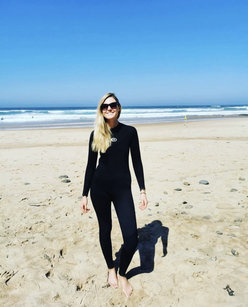 Frau am Strand im Wetsuit beriet zum Surfen in Portugal.
