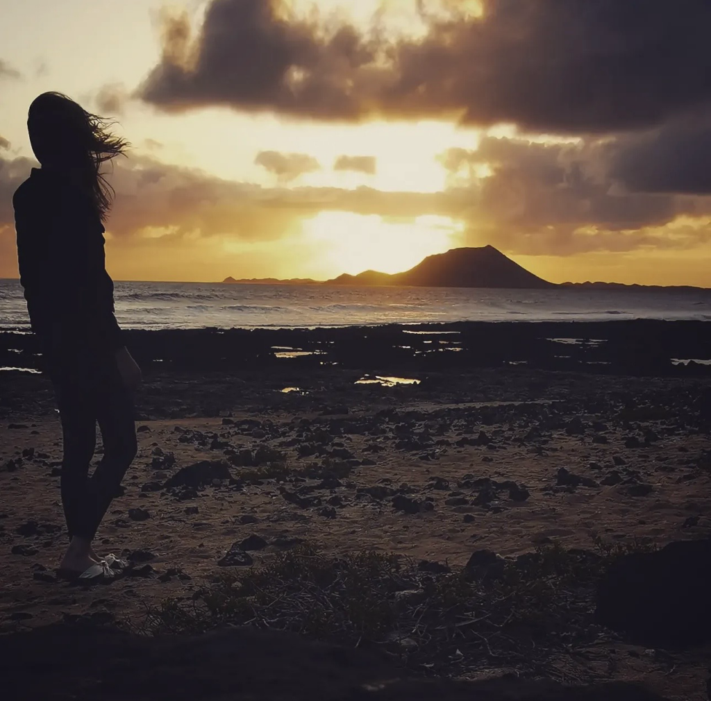 Frau am Strand mit Sonnenaufgang auf Fuerteventura.