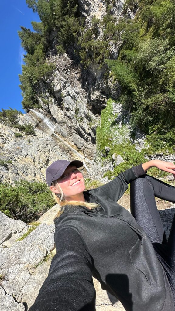 Allein reisende Frau an einem Wasserfall in der Schweiz in Lenzerheide